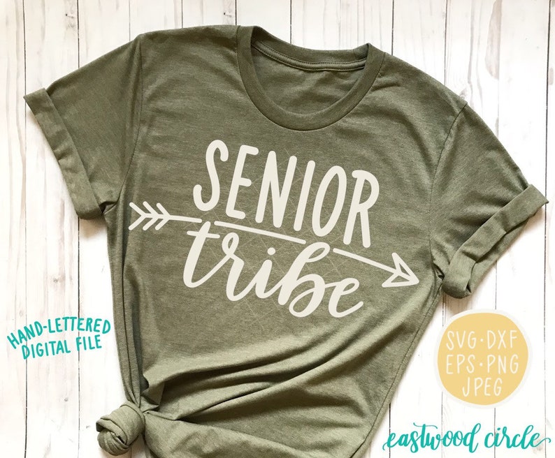 May include: A green t-shirt with the text "SENIOR tribe" in white lettering and an arrow graphic. The text is in a handwritten style font.