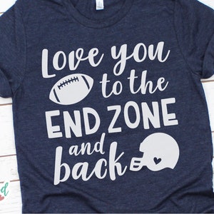 May include: A navy blue t-shirt with white text that reads "Love you to the end zone and back". The text is accompanied by a white football and a white football helmet with a small heart inside.