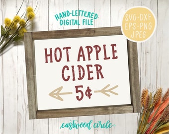 Puede incluir: Un letrero de madera rústico con el texto "HOT APPLE CIDER 5€" en letras rojas y marrones. El letrero está enmarcado en un marco de madera marrón y tiene un fondo blanco. El letrero está sobre un fondo de madera blanco.