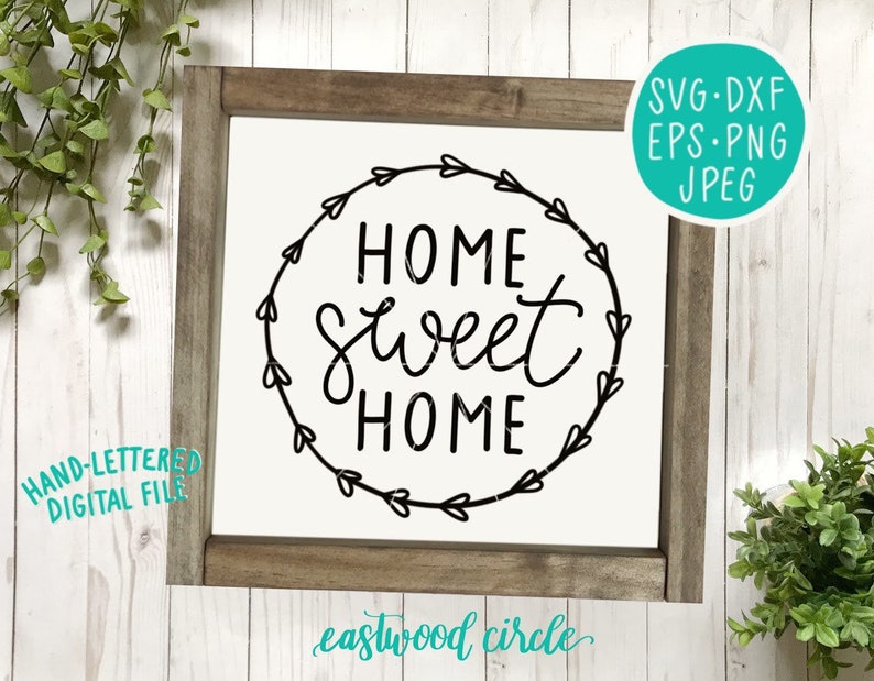 以下が含まれることがあります： 「Home Sweet Home」と手書きで書かれたデザインの白黒デジタルダウンロード。ハートのリースで囲まれた円形です。デザインは白い背景に木製のフレームで飾られています。