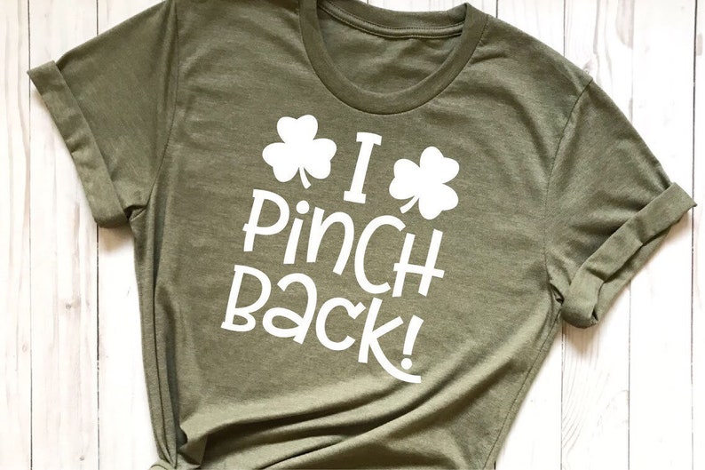 Puede incluir: Una camiseta verde con texto blanco que dice "I Pinch Back!" y dos dise&ntilde;os de tr&eacute;bol.