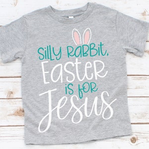 May include: Gray t-shirt with a white graphic that says "Silly Rabbit, Easter is for Jesus" with pink bunny ears above the text.