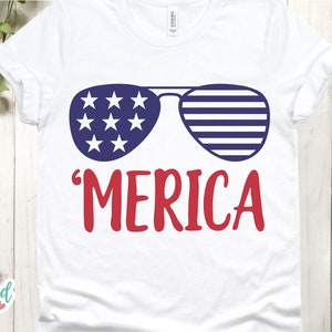 Puede incluir: Camiseta blanca con un dise&ntilde;o patri&oacute;tico. El gr&aacute;fico presenta gafas de sol con rayas y estrellas azules y blancas, y la palabra "'MERICA" en rojo. Un dise&ntilde;o divertido y festivo para el D&iacute;a de la Independencia.