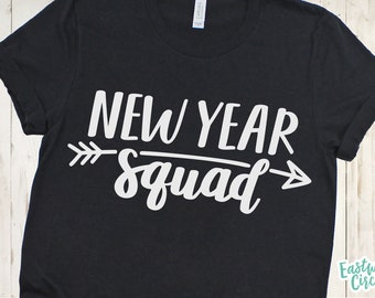Può includere: Maglietta nera con testo bianco che recita "New Year Squad" con frecce su entrambi i lati del testo.