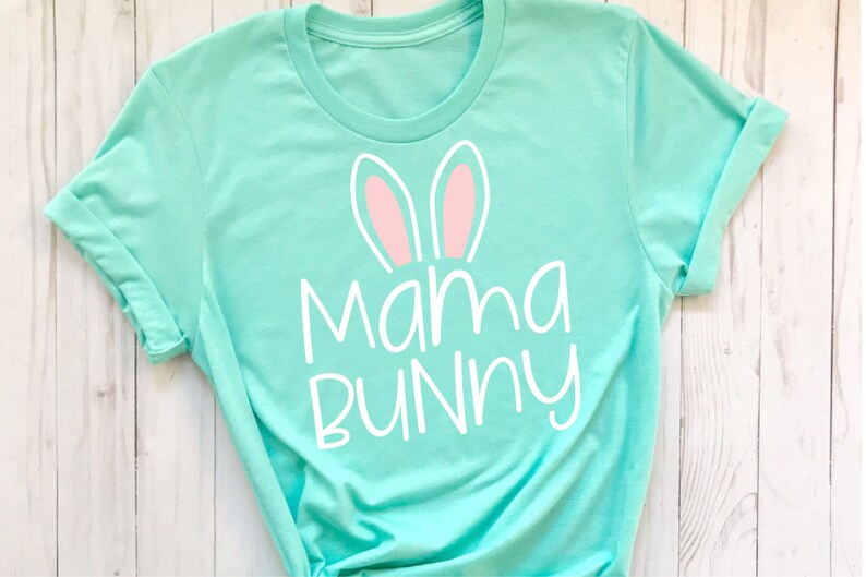 May include: A turquoise t-shirt with white text that says "Mama Bunny" and pink bunny ears.