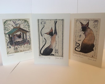 Könnte beinhalten: Drei signierte Kunstdrucke mit siamesischen Katzen in verschiedenen Posen. Der erste Druck zeigt eine Katze, die in einem Vogelhaus sitzt, der zweite zeigt eine Katze, die sich streckt, und der dritte zeigt eine Katze, die mit dem Schwanz um die Beine gewickelt sitzt. Jeder Druck hat einen Titel und ist vom Künstler "Marian Foster" signiert.