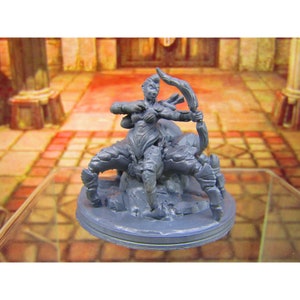 May include: A gray 3D printed miniature of a female humanoid figure with spider-like legs holding a bow and arrow. The figure is standing on a round base.