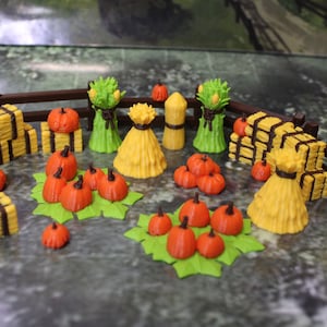 May include: A collection of miniature fall harvest decorations, including hay bales, pumpkins, and corn stalks. The decorations are made of yellow, orange, brown, and green plastic.
