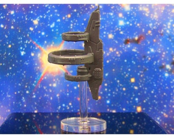 May include: A gray spaceship model with three rings, mounted on a clear plastic stand. The spaceship is in a vertical position, with the rings stacked on top of each other.
