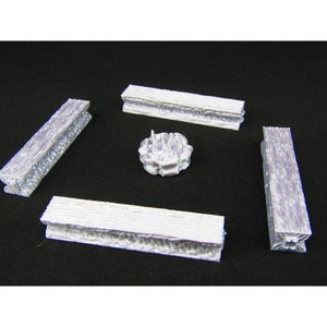 May include: Four white wooden benches surround a small white stone fire pit. The benches are made of rough-hewn wood and have a rustic look. The fire pit is a simple design with a raised lip and a small opening in the center.