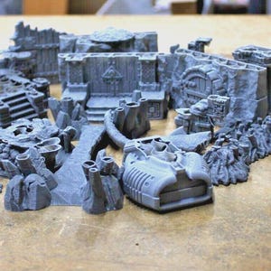 May include: A set of 3D printed dungeon tiles for tabletop gaming. The tiles are made of gray plastic and feature various textures and details, including walls, doors, and floors. The tiles are designed to be used with miniature figures and other gaming accessories.