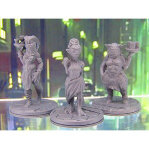 May include: Three gray painted miniature figurines of fantasy creatures. The figures are standing on round bases. The figures are wearing clothing and holding objects.