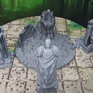May include: Four gray 3D printed figurines standing around a circular base with a broken, cracked surface. The figurines are in various poses and appear to be wearing armor and robes.