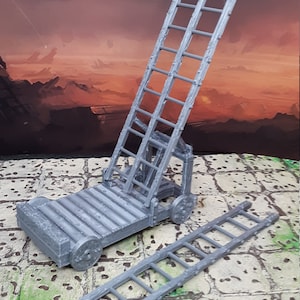 May include: A grey plastic model of a siege ladder on wheels. The ladder is extended and has a second ladder lying on the ground next to it.