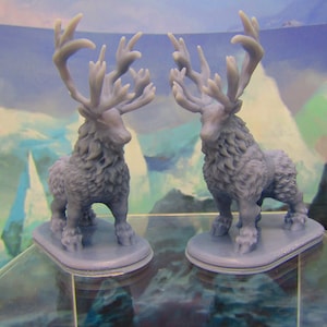 May include: Two gray 3D printed figurines of a deer with large antlers. The deer are standing on a gray base and are facing each other.