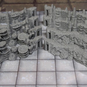 May include: A set of gray 3D printed dungeon wall pieces for tabletop gaming. The pieces are designed to be modular and can be used to create a variety of different dungeon layouts.