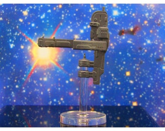 May include: A gray, detailed, miniature spaceship model on a clear plastic stand. The spaceship has a long, thin arm extending out from the main body. The background is a blue and white starry sky.