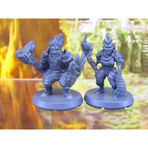 May include: Two blue painted miniature figurines of fantasy characters. The figures are standing on round bases. The figure on the left is holding a book and a shield. The figure on the right is holding a staff and a snake.