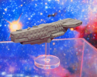 May include: A gray plastic spaceship model on a clear plastic base. The spaceship has a long, narrow body with a pointed nose and a series of small windows along the side. The model is set against a blue and pink background with a starfield pattern.