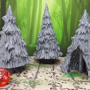 May include: Three gray plastic miniature trees, two are upright and one is a hollowed-out tree with an opening. The trees are on a brown and green patterned surface with a red twenty-sided die.
