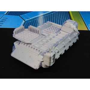 May include: A gray 3D printed model of a futuristic vehicle with a raised platform and a textured surface.