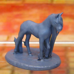 May include: A blue plastic miniature horse figurine standing on a round base. The horse has a long mane and tail.