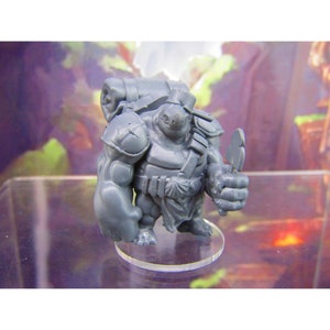 Peut inclure: Une figurine miniature en plastique gris d'une créature ressemblant à une tortue portant une armure et un sac à dos. La figurine tient une petite hache dans sa main droite et se tient sur une base en plastique transparente.