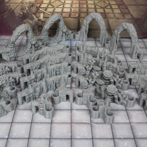 May include: A collection of gray 3D printed dungeon tiles for tabletop role-playing games. The tiles feature various shapes and textures, including arches, walls, and rubble.