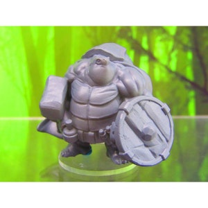 May include: A gray, 3D printed miniature of a turtle-like creature wearing armor and holding a hammer and shield.