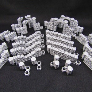 May include: A set of gray plastic miniature castle wall and archway pieces for tabletop gaming or model building.