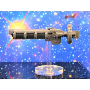 May include: A gray, detailed spaceship model with a circular rear section and multiple rectangular protrusions along the side. The model is mounted on a clear plastic stand.