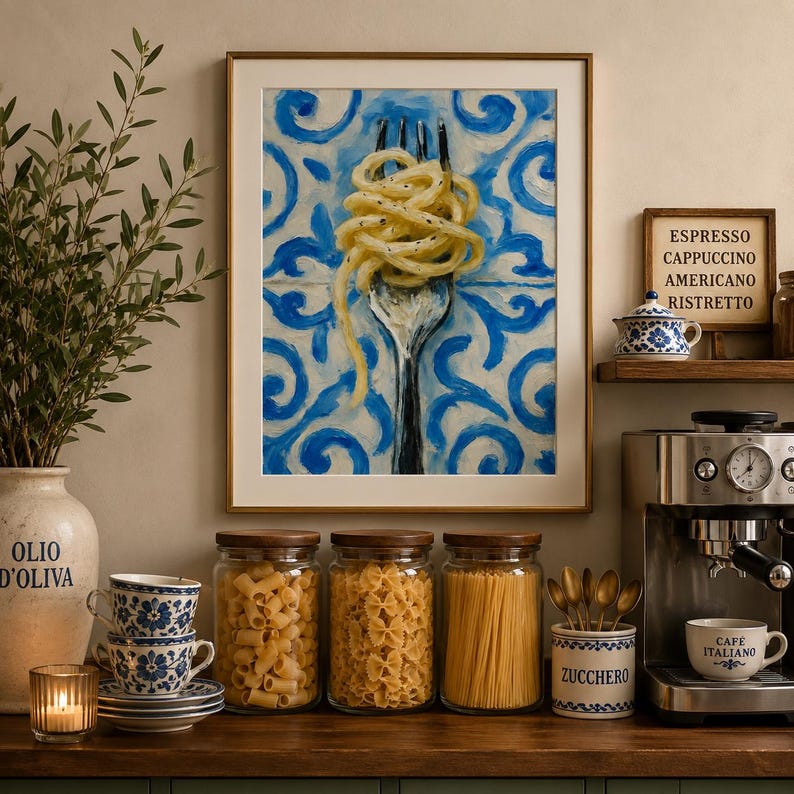 May include: A framed wall art print featuring a painting of a silver fork twirling spaghetti against a blue and white patterned tile background. The artwork is displayed in a kitchen setting with glass jars of pasta and a coffee machine nearby.