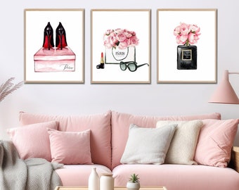 May include: Three framed prints with a pink and white color scheme. The first print features a pair of black high heels in a pink box with the word "Paris" written on it. The second print features a white shopping bag with pink flowers and a pair of sunglasses. The third print features a bottle of perfume with pink flowers.