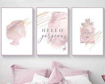 May include: Three pink and gold watercolor prints with the text "Hello gorgeous", a silhouette of a woman's head, and a bottle of perfume with the text "Eau de Parfum Paris".