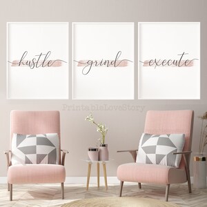 May include: Three framed prints with a pink brushstroke design and black calligraphy. The prints read "hustle", "grind", and "execute".