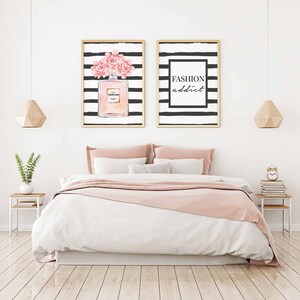Op de afbeelding: Twee ingelijste prints met zwart-witte strepen. De print aan de linkerkant heeft een roze bloemenontwerp en een fles parfum. De print aan de rechterkant heeft de tekst "FASHION addict".