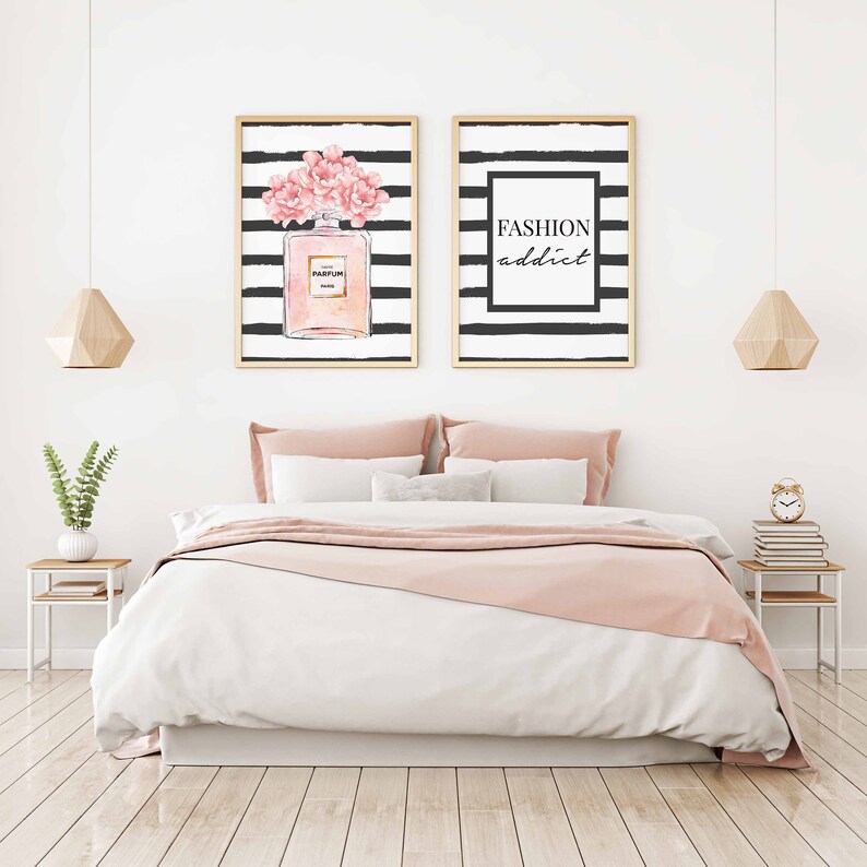 Op de afbeelding: Twee ingelijste prints met zwart-witte strepen. De print aan de linkerkant heeft een roze bloemenontwerp en een fles parfum. De print aan de rechterkant heeft de tekst "FASHION addict".