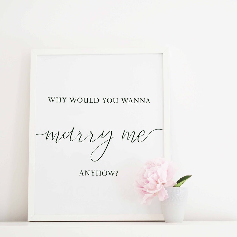 Puede incluir: Impresi&oacute;n enmarcada en blanco con texto negro que dice "WHY WOULD YOU WANNA marry me ANYHOW?" con una peon&iacute;a rosa en un jarr&oacute;n blanco sobre una superficie blanca.