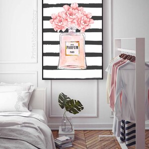 Op de afbeelding: Een zwart-wit gestreepte achtergrond met een roze parfumfles en roze bloemen. De fles heeft de tekst "Eau de Parfum Paris".