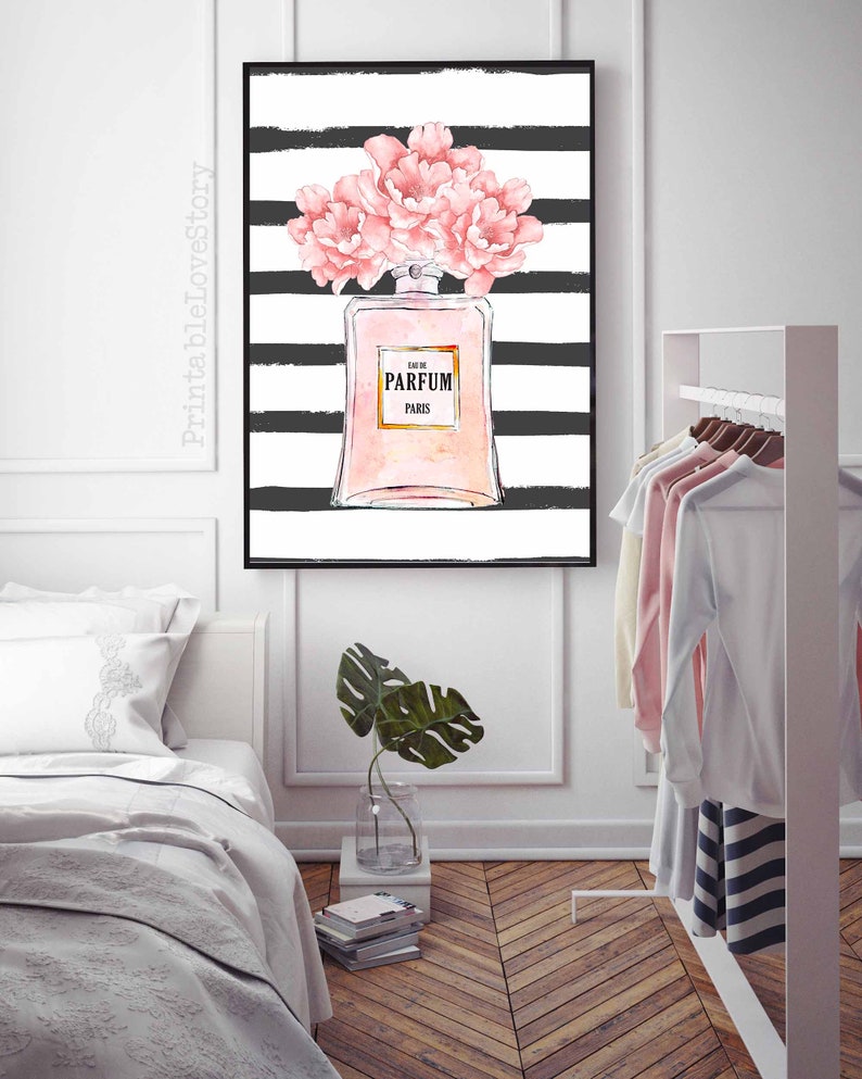 Op de afbeelding: Een zwart-wit gestreepte achtergrond met een roze parfumfles en roze bloemen. De fles heeft de tekst "Eau de Parfum Paris".