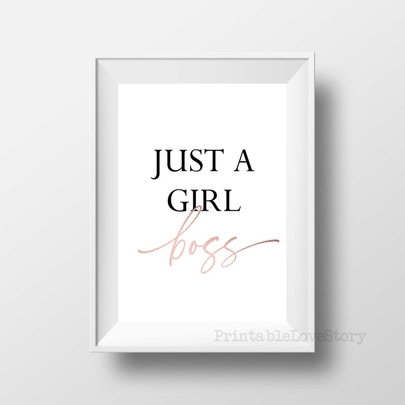 Puede incluir: Una impresi&oacute;n enmarcada en blanco con el texto "JUST A GIRL boss" en letras negras y doradas.