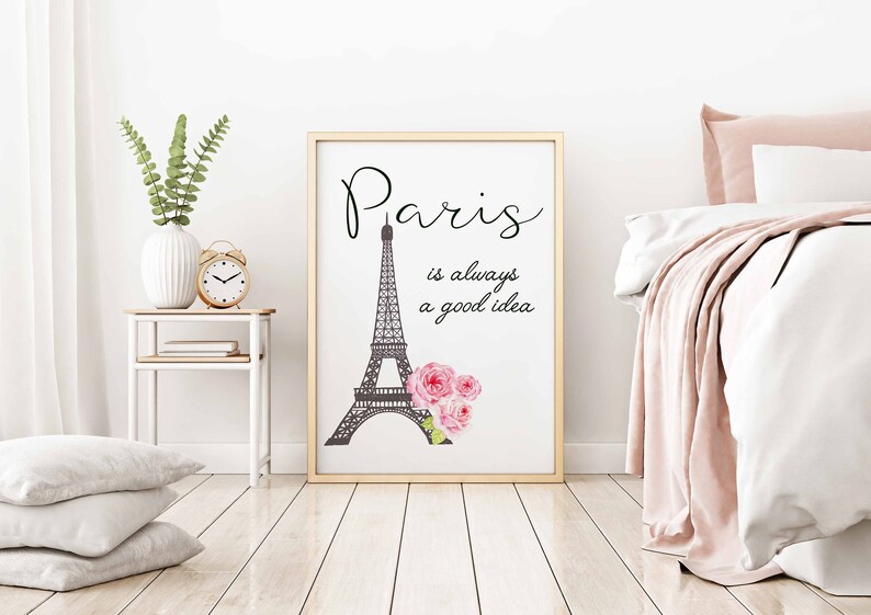 May include: A white framed print with a black and white illustration of the Eiffel Tower and pink flowers. The text "Paris is always a good idea" is written in black cursive font.