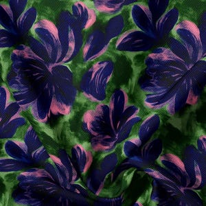 May include: A fabric featuring a vibrant green background with a tie-dye effect, overlaid with a repeating pattern of large, stylized flowers in deep navy blue and soft pink. The material has a visible woven texture and folds throughout the surface.