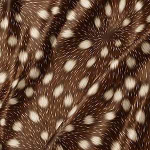 May include: A fabric featuring a brown base color with a repeating pattern of white, oval-shaped spots. The material has a textured appearance with visible folds and drapes, creating a soft, fur-like visual effect across the entire surface.