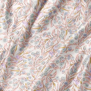May include: A white fabric featuring a repeating botanical pattern of light pink leaves and small, soft blue berries. The design is rendered in a fluid, hand-drawn style with delicate lines and subtle colour variations across the surface.