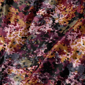 May include: A textile fabric featuring an abstract, mottled pattern in shades of deep burgundy, mustard yellow, soft pink, and charcoal black. The surface has a textured, woven appearance with irregular color patches distributed across the material.
