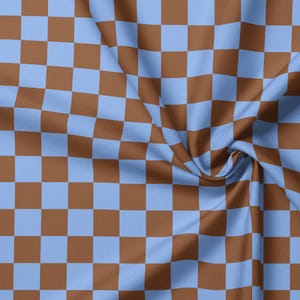 May include: A fabric featuring a repeating chequered pattern of light blue and brown squares. The material displays a soft, draped texture with folds that create subtle shadows, highlighting the consistent grid layout across the surface.