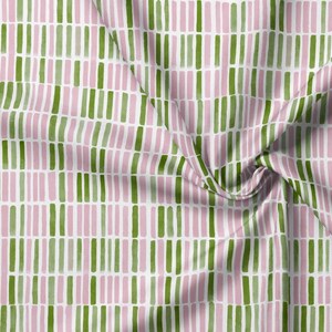 May include: A textile fabric featuring a repeating pattern of vertical rectangular bars in alternating shades of light pink and olive green, arranged in a structured grid layout against a clean white background with visible fabric folds.