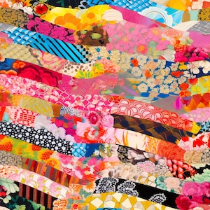 May include: A colourful patchwork fabric featuring a range of floral patterns and textures. The fabric is arranged in a wavy pattern, creating a dynamic and visually appealing design.