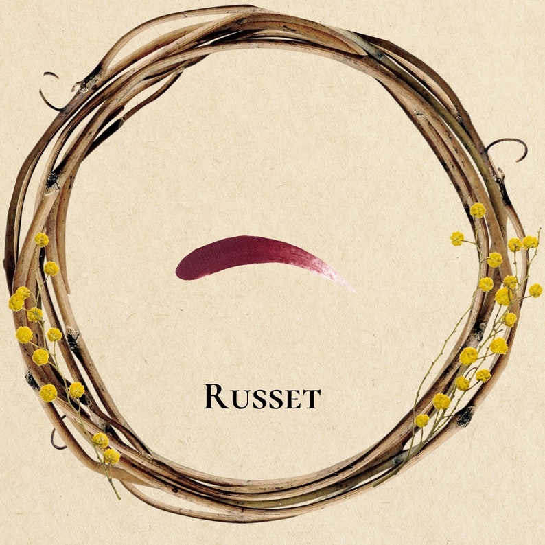 Pu&ograve; includere: Una ghirlanda di ramoscelli marroni con fiori gialli, una pennellata di vernice rossa e la parola "RUSSET" in testo nero.